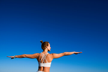 girl doing yoga on a sky background