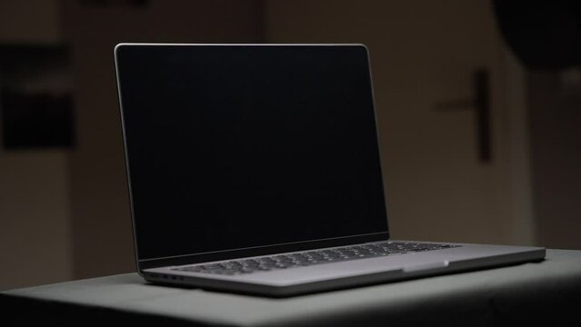 Cinematic footage of an Apple M1 MacBook Pro 14 inch with an overhead light filmed at a tight focal length in 4k in slow motion shot in the studio with controlled light with some slow movement