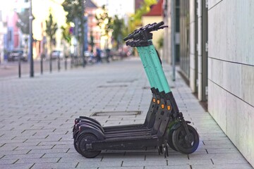 Parked e-shooters for rent on the sidewalk.