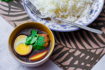 Steamed rice in an ancient plate and Stewed Eggs, Thai food and street food that are common in Thailand.