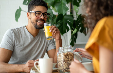 Happy couple having breakfast together in the kitchen