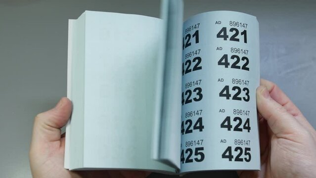 Flicking through a book of raffle tickets