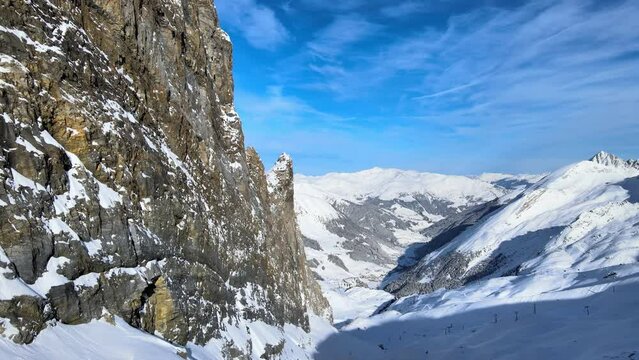 snowy mountains and rocky cliffs in a winter wonderland in the alpes drone 4k truck reveal shot