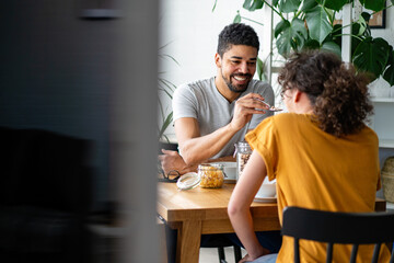 Happy african american couple having breakfast together in the kitchen