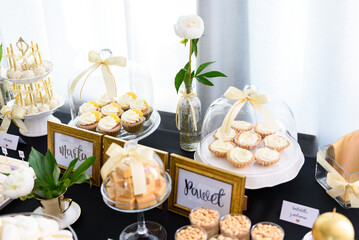 Tasty sweets on the black tablecloth at the wedding party