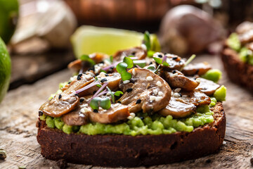Toast avocado, mushrooms and microgreen whole grain sandwich. Decorated with sesame. Vegetarian food. Vegan menu. Delicious breakfast or snack, Clean eating, dieting, vegan food concept. top view