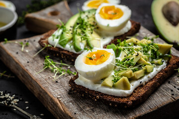 Two toasts with avocado, poached egg and microgreen. diet or vegetarian food. Top view