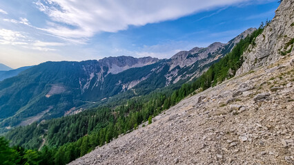Hiking trail full of rocks, scree and rubble on the way to mount Mittagskogel in Karawanks in Carinthia, Austria. Scenic view on mountain ridges. Borders Austria, Slovenia, Italy.Triglav National Park