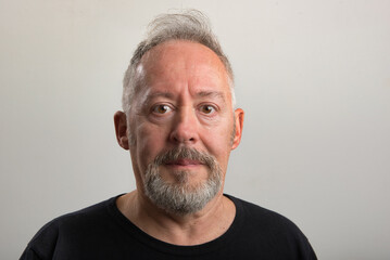 Close up photo of middle aged man, with beard and grey hair