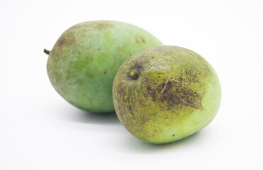 A raw mango beside a ripe mango isolated on white background