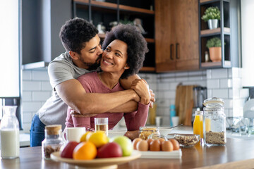 Happy couple having breakfast together in the kitchen