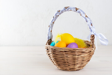 Easter eggs in a basket on a wooden table. Horizontal orientation, copy space.