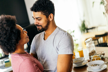 Happy couple having breakfast together in the kitchen