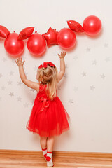 girl in red dress and red balloons