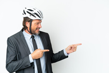 Business senior man with a bike helmet isolated on white background pointing finger to the side and presenting a product