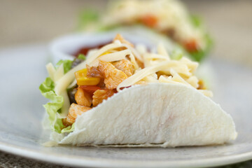 Tacos with chicken, tomatoes, corn and onions. Mexican food. Fast food. Authentic mexican tacos with chicken and salsa with avocado, tomatoes and chillies. Mexican cuisine. Top view