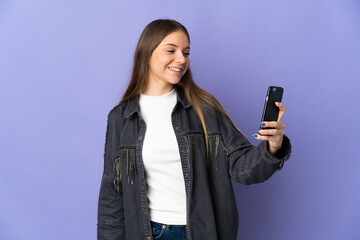 Young Lithuanian woman isolated on purple background making a selfie