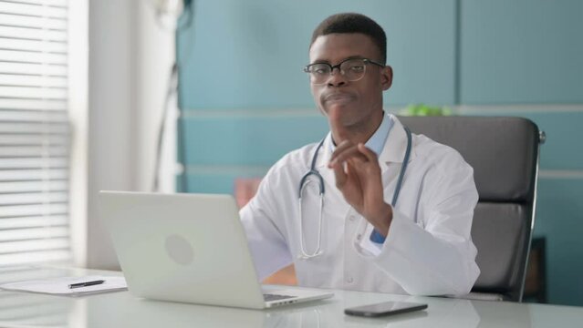 Young African Doctor Shaking Head as No Sign while using Laptop in Office
