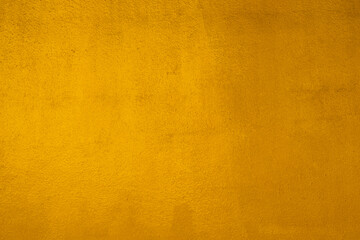 Fototapeta premium Gold wall texture background. Yellow shiny gold paint on concrete wall surface