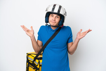 Young caucasian man with thermal backpack isolated on white background having doubts while raising hands