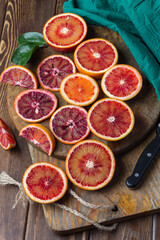Sliced Sicilian Blood oranges on wooden background. Top view. Flat lay. Selective focus.
