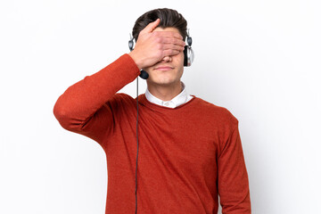 Telemarketer caucasian man working with a headset isolated on white background covering eyes by hands. Do not want to see something