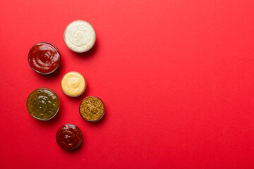 Different types of sauces in bowls on a colored Board . Top view. various sauces copy space