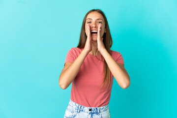 Young woman over isolated blue background shouting and announcing something