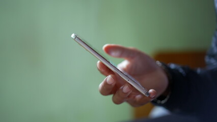 Hand holding smartphone watching content online closeup