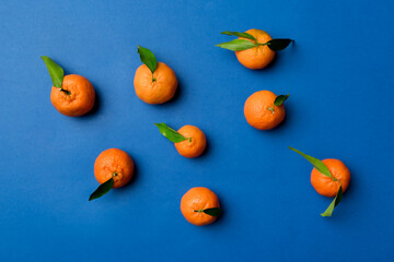 Many fresh ripe mandarin as colored background, top view. Elegant background of clementines and mandarin slices Top view flat lay