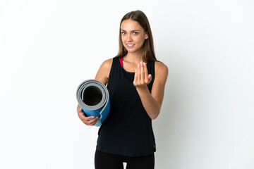 Obraz premium Sport woman going to yoga classes while holding a mat over isolated white background inviting to come with hand. Happy that you came