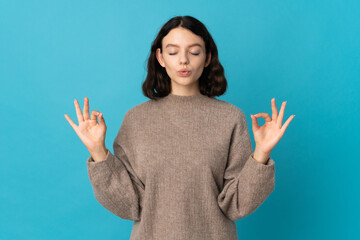 Teenager Ukrainian girl isolated on blue background in zen pose