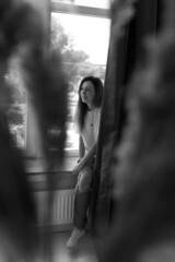 a girl in therapy at a consultation with a psychologist emotionally talks about problems situations smiling gets embarrassed sits on the windowsill and looks out the window