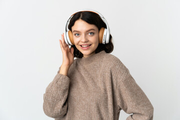 Teenager Ukrainian girl isolated on white background listening music