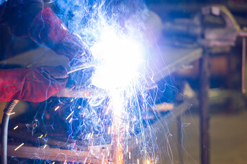 Fototapeta na wymiar man in workshop working with metal and welding