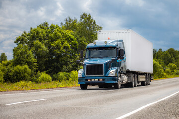 Blue truck on a road in summer