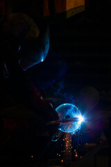 man in workshop working with metal and welding
