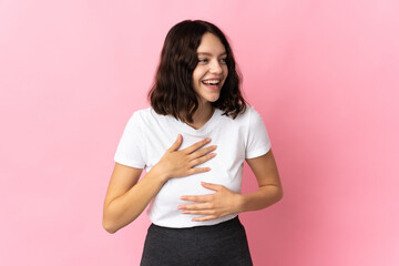 Teenager Ukrainian girl isolated on pink background smiling a lot