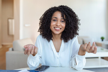 African-american elegant female entrepreneur discussing while having a conference call Portrait of confident ethnicity female employee looking at camera talking on video call in the home office. - obrazy, fototapety, plakaty