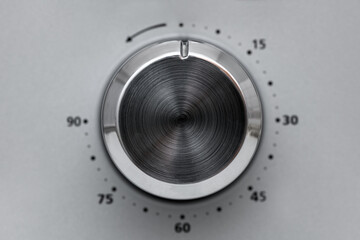 Close-up Circular button to control the temperature in the microwave oven. Button to warm food on gray background