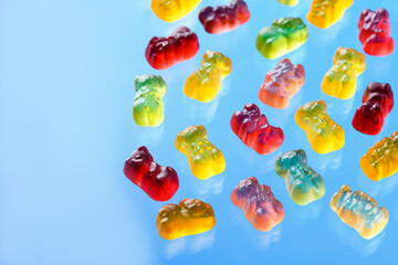 Multicolored flying gummy bears on blue background
