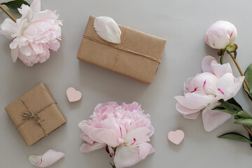 Gift wrapping and delivery. Gift boxes, craft packaging design and peony flowers on a beige background, top view. wedding, mother's day, birthday layout. Place for text