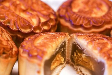 Sliced mooncake showing delicious sweet Lous seed paste and egg yolk filling, traditional Mid-autumn Festival treat, selective focus