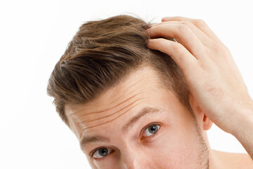 Stressed man with graying hair looking in mirror