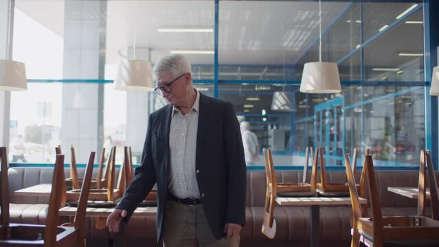 Mature businessman walk in empty closed restaurant. Realtime