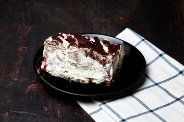 Plate with slice of tasty chocolate cake on table. Yummy dessert on on wooden background, closeup