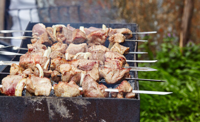 Marinated shashlik preparing on a barbecue grill over charcoal. Traditional Russian shashlik on a barbecue skewer