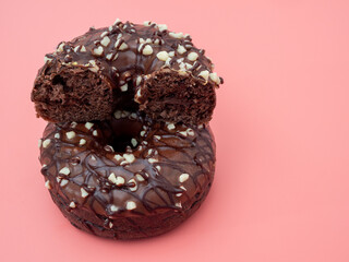 Fresh chocolate donut on a pink background. Chocolate donut