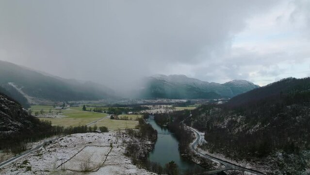 Stor&aring;na River In &Aring;rdal With Panorama of Mountains Obscure With Clouds And Fog At Winter In Norway. - aerial