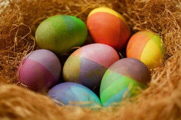 Pastel Easter eggs in nest on a sunny yellow background. Minimal creative concept of Easter.